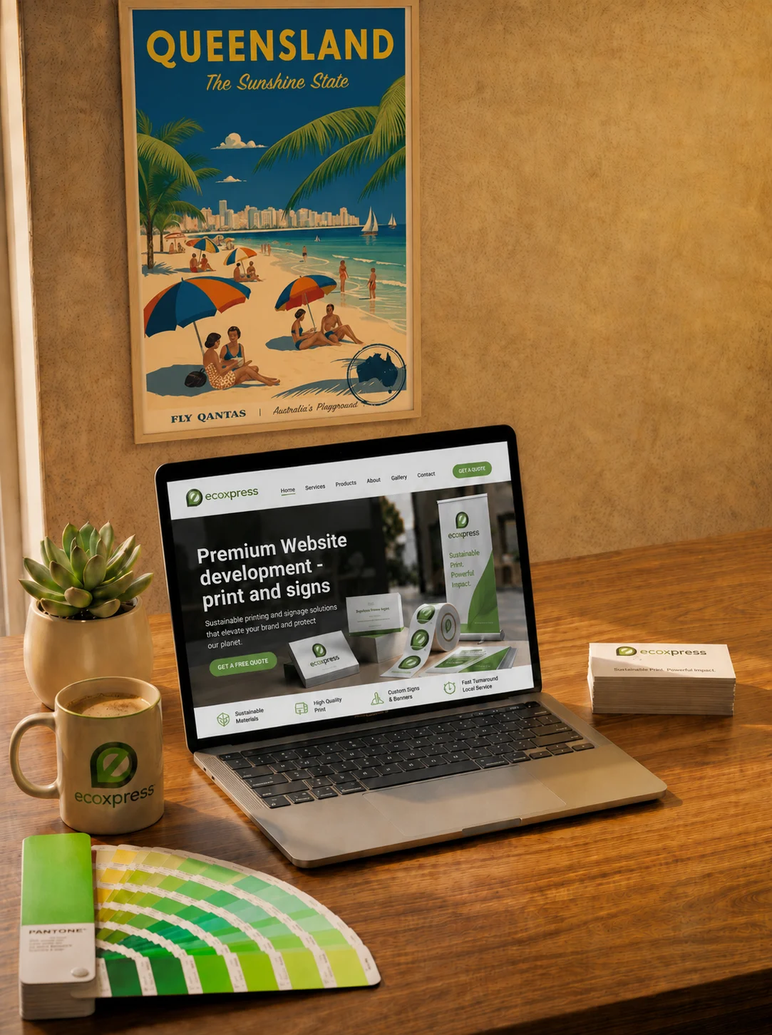EcoExpress branded website, print samples and colour swatches arranged on a timber desk under a Queensland poster