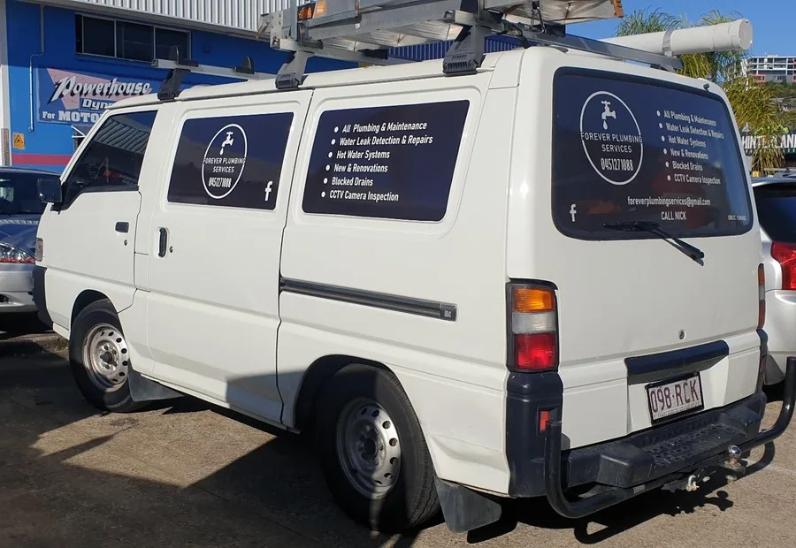 Forever Plumbing Services white service van with custom trade signage and window graphics